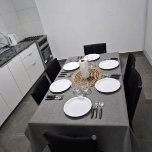 a dining room table with white plates and silverware at Departamento LUNA DE BELEN in Belén