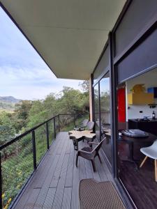 a wooden deck with chairs and tables on a balcony at Cabaña Guane in Pacho +11 photos