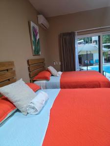 a bedroom with two beds with red and white sheets at Vidalta Hotel Boutique in Retalhuleu