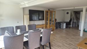 a dining room with a table and chairs and a flat screen tv at Michelle's Yellow house in Ilulissat