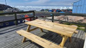 a wooden bench sitting on top of a wooden deck at Michelle's Yellow house in Ilulissat