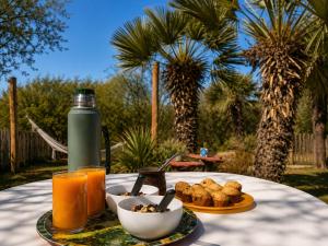 a table with a plate of food and a bottle of orange juice at Cabañas Caranday in Capilla del Monte