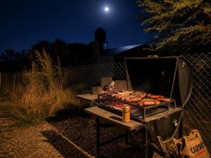 a grill with food on top of it at night at Cabañas Caranday in Capilla del Monte