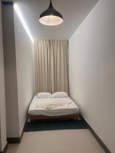 a small white bedroom with a bed and a window at Salo in Georgetown