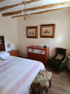 a bedroom with a large bed and a chair at La calma de Arnedillo in Arnedillo