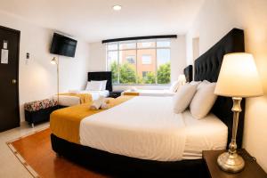 a bedroom with a large bed and a large window at House Studio Hotel in Bogotá +28 photos