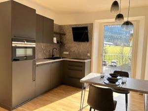 a kitchen with a table with chairs and a dining room at Murleben Top 06 in Stadl an der Mur