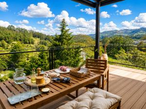 a table on a deck with a view of the mountains at Verso el Retiro in El Retiro