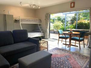 a living room with a couch and a bed and a table at Pickmere Oasis in Kerikeri +14 photos