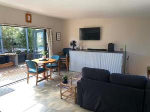 a living room with a couch and a table at Pickmere Oasis in Kerikeri