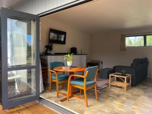 a living room with a table and chairs at Pickmere Oasis in Kerikeri