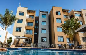 a hotel with a swimming pool in front of a building at KIGALI E6 APARTMENTs RESORTS in Kigali