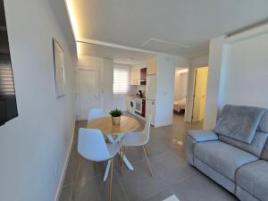 a living room with a couch and a table and chairs at Alborada in Corcubión