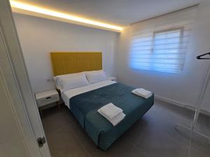 a bedroom with a bed with two towels on it at Alborada in Corcubión