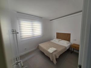 a small bedroom with a bed and a window at Alborada in Corcubión