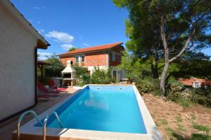 a swimming pool in front of a house at Holiday house with a swimming pool Basina, Hvar - 8731 in Vrbanj