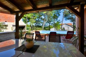 a patio with a table and chairs and a pool at Holiday house with a swimming pool Basina, Hvar - 8731 in Vrbanj
