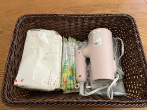 a wicker basket with a hair dryer and other items at あわら湯のまち駅から徒歩3分の湯の花ハウス in Awara