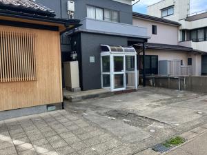 a house with an open door in a parking lot at あわら湯のまち駅から徒歩3分の湯の花ハウス in Awara