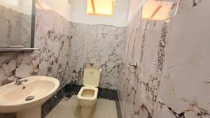 a bathroom with a white toilet and a sink at Blissful Chateau in Batigama +31 photos
