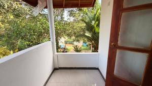 a door to a balcony with a view of a yard at Blissful Chateau in Batigama