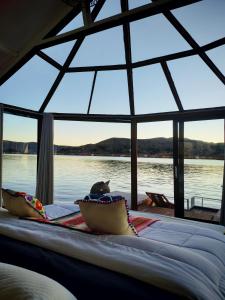 a bed in a room with a view of the water at Titicaca Star Perú in Puno