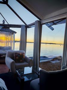 a living room with a chair and a view of the water at Titicaca Star Perú in Puno