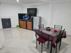 a kitchen with a table with chairs and a refrigerator at Kandy City View Apartments in Kandy