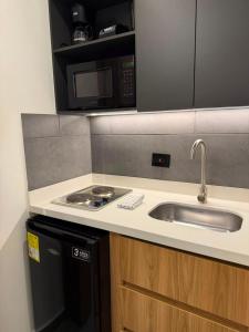 a kitchen with a sink and a microwave at Once Suites in Envigado +44 photos