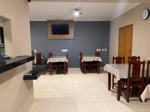 a dining room with tables and chairs and a tv at Point Hotel in Tanabi +4 photos