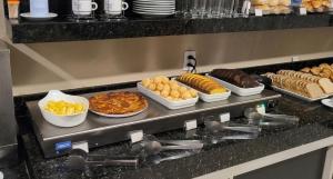 a buffet with different types of food on a counter at Point Hotel in Tanabi