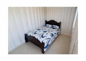 a bed with a blue and white comforter in a bedroom at Finca LA HERMOSA in Guzmán