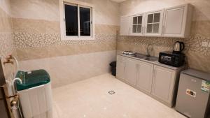 a small kitchen with white cabinets and a sink at أرياف سويت in Al Baha +7 photos