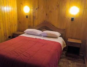 a bedroom with a red bed with two pillows at Hospedaje Francesco in Puerto Montt