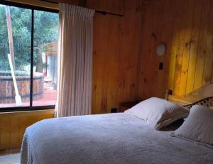 a bedroom with a bed and a large window at Hospedaje Francesco in Puerto Montt
