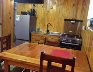 a kitchen with a table and a stove and a refrigerator at Hospedaje Francesco in Puerto Montt