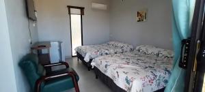 a hospital room with two beds and a chair at Cacique Room 2 in Playa Hermosa