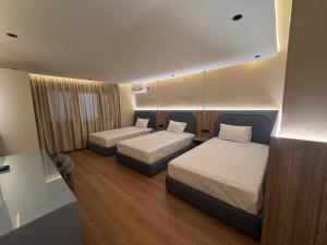 a hotel room with two beds and a desk at Appart Hotel Star in Tangier