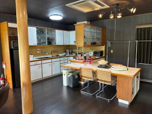 a kitchen with white cabinets and a table with chairs at Cool-Villa 飛騨リゾート in Hida