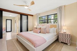 a bedroom with a large bed with pink and white pillows at The Coastal Duo Escape in West Palm Beach +165 photos