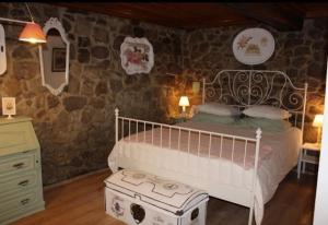 a bedroom with a bed and a stone wall at Quinta da Maínha - Charming Houses - com piscina privada in Braga