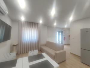 ein weißes Wohnzimmer mit einer Couch und einem Kühlschrank in der Unterkunft Barcelos Habadia Espigueiro in Lijó