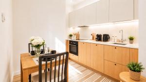 a kitchen with wooden cabinets and a wooden table at GuestFirst- Modern Boho Charm in Kallio Helsinki Center in Helsinki