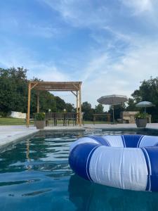 a pool with blue inflatables and a pergola at Quinta da Maínha - Charming Houses - com piscina privada in Braga