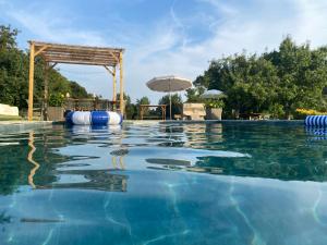 a swimming pool with an umbrella and a swimming pool at Quinta da Maínha - Charming Houses - com piscina privada in Braga