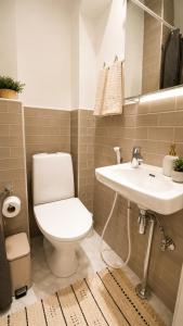a bathroom with a toilet and a sink at GuestFirst- Modern Boho Charm in Kallio Helsinki Center in Helsinki