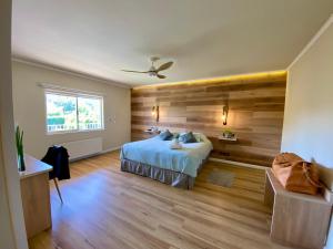 a bedroom with a bed and a wooden wall at EcoHotel El Almendro in Paine