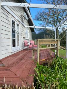 a porch with a bench on a wooden deck at Waitomo Farmstay - Rimu Cottage 2 in Waitomo Caves