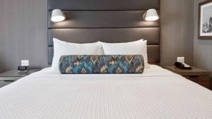a bed in a hotel room with a pillow on it at Zemira Apartments in Abuja