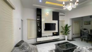 a living room with a tv on a wall at Zemira Apartments in Abuja